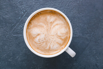 Cup of tasty latte on dark background