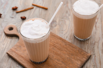 Glasses of tasty latte on wooden background
