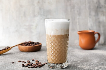 Glass of tasty latte on grey background