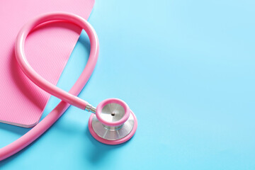 Fototapeta premium Stethoscope and notebook on color background, closeup