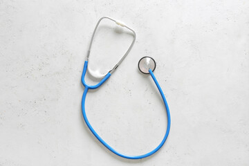 Modern stethoscope on light background