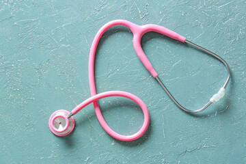 Modern stethoscope on color background
