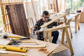 Asian joiner assembling wooden furniture