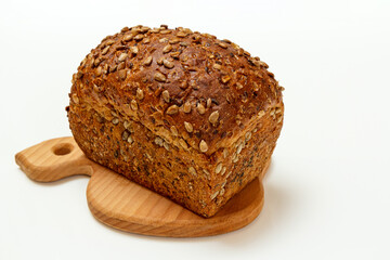 Loaf of bread on wooden cutting board on white background