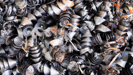 Steel scrap materials recycling. Aluminum chip waste after machining metal parts on a cnc lathe. Closeup twisted spiral steel shavings. Small roughness sharpness,