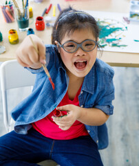Asian girl with Down syndrome showing paint