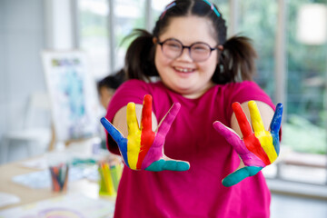 Asian girl with Down syndrome showing painted hands