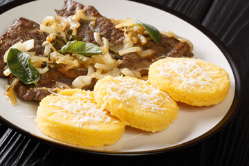 Liver with Onions Sage and Vinegar Fegato Alla Veneziana with polenta closeup in the plate on the table. Horizontal