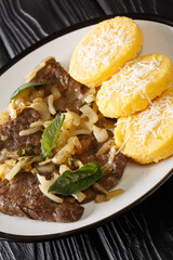 Fegato alla Veneziana Calf's Liver and Onions with polenta closeup in the plate on the table. Vertical