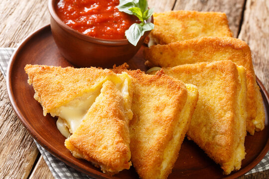 Mozzarella in carrozza is an Italian cheese sandwich made by breading and frying mozzarella-stuffed bread closeup in the plate on the table. horizontal