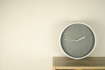 gray round clock mounted on white wall background