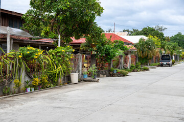 Asian village street view with modern houses and green plants. Tropical island native village view with no people. Philippines architectural style. Apartment rent or lease concept banner template - 420959754