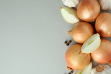 Fresh onion and peppercorns on light gray background