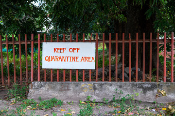Keep Out Quarantine Area handmade banner sign on metallic fence. COVID-19 hospital surrounding...