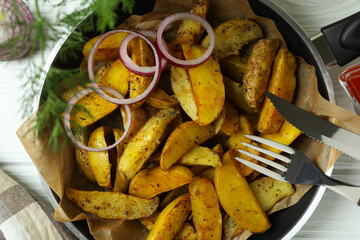 Concept of tasty meal with pan of tasty potato wedges