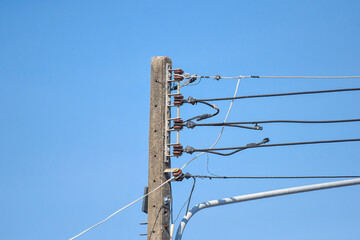 top of electric pole with clear blue sky