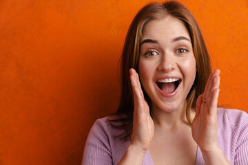 Young ginger excited woman looking and screaming at camera