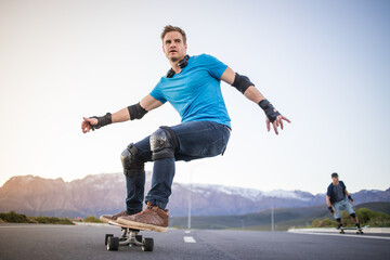 Skateboarder skateboarding on an open road doing freestyle tricks