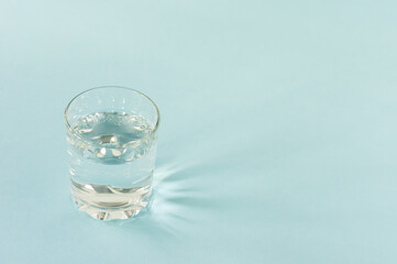 a glass of pure water on blue background. copy space for text. consept of healt life and diet