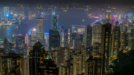 The most famous view of Hong Kong at twilight sunset. Hong Kong skyscrapers skyline cityscape view from Victoria Peak illuminated in the evening. 
