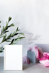 Mock-up poster white frame in modern interior. Minimal composition with a white photo frame and bright fabric, in a Scandinavian interior.