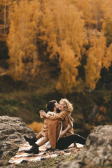 Happy in love romantic young cheerful couple man and woman married travel hiking walk together among the autumn forest and mountains looking for adventure enjoy the local nature, selective focus