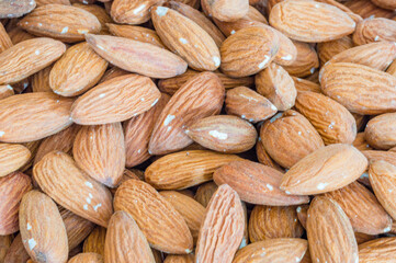 Shelled almonds (Prunus dulcis) as background.