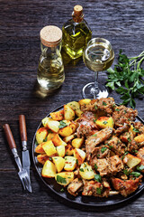 braised Rabbit with potatoes on a black plate