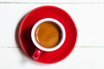 top view of red cup with fresh coffee on saucer on white background, panoramic shot
