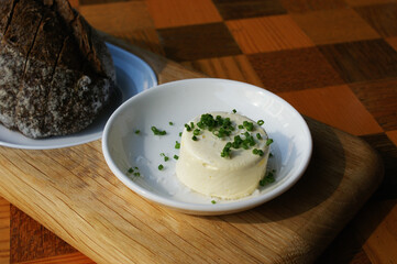 butter on a plate, on the background of black bread. freshly sprinkled butter