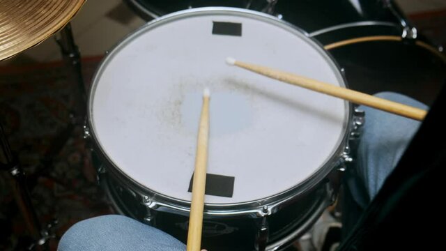 The drummer plays with sticks on a snare drum, home lesson training.
