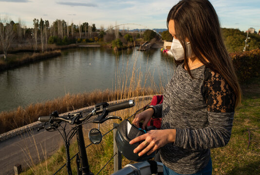 Girl with helmet mask and her bicycle.