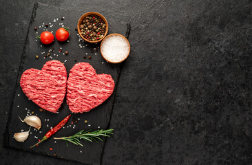 minced meat in the shape of a heart on a stone background with copy space for your text