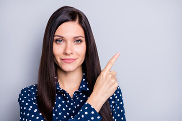 Portrait of optimistic good brunette girl point empty space wear blue blouse isolated on grey color background © deagreez