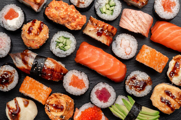Assorted sushi nigiri and maki big set on slate. A variety of Japanese sushi with tuna, crab, salmon, eel and rolls. Top view © Andrey