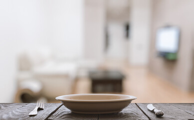 empty plate with fork and knife on wooden table