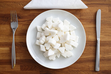 White sugar lies on plate next to fork and knife