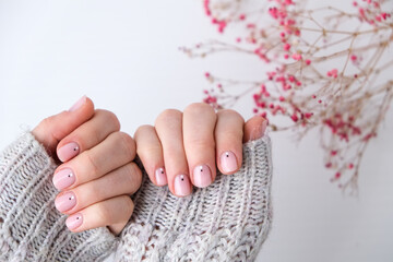 Woman hands with beautiful nude manicure holding delicate pink Gypsophila or baby's breath flowers....