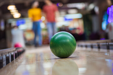 Couple playing bowling. Focus on ball.