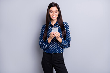 Photo of optimistic girl look telephone wear blue blouse trousers isolated on grey color background