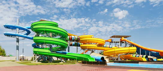 water park, bright multi-colored slides with a pool, a water park on a summer day