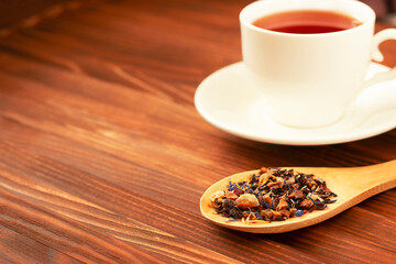 dried tea leaves and brewed tea in a white mug