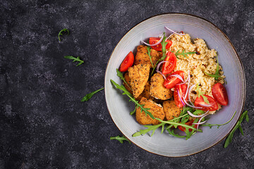 Boiled bulgur, roasted chicken nuggets and fresh tomatoes salad. Middle eastern cuisine. Top view, flat lay