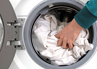 Man filling laundry in the washing machine