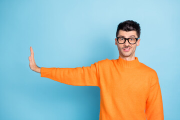 Photo of negative young guy grin teeth show arm palm rejection empty space isolated on blue color...