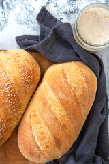 Homemade white bread, loaf of sourdough bread. Fresh loaf of bread and a glass jar with sourdough sourdough