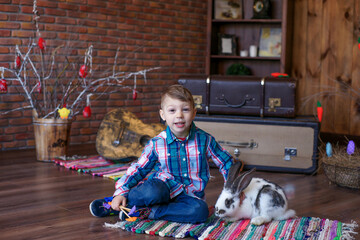 boy in a good mood plays with an Easter bunny, joy on the baby's face