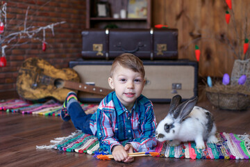 boy in a good mood plays with an Easter bunny, joy on the baby's face