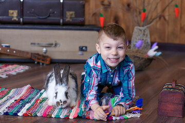 boy in a good mood plays with an Easter bunny, joy on the baby's face