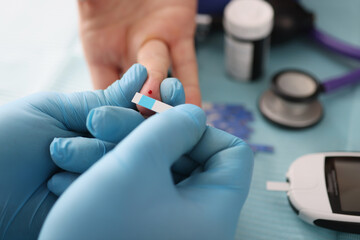 Doctor draws blood for aglucose test closeup